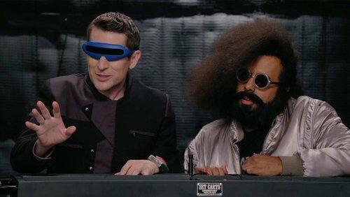 Reggie Watts Wears a Purple and Yellow Quilted Sweatshirt Reggie Watts Wears a Purple and Yellow Quilted Sweatshirt